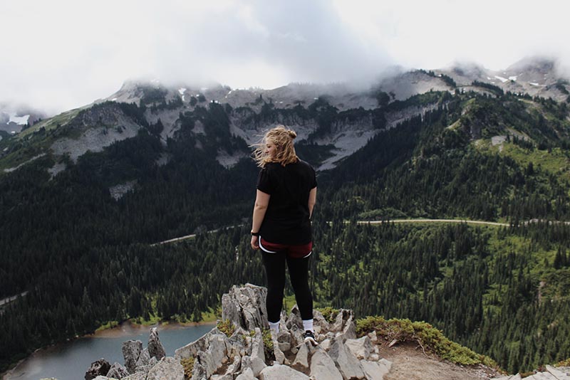woman on a hike looks out at view of mountains