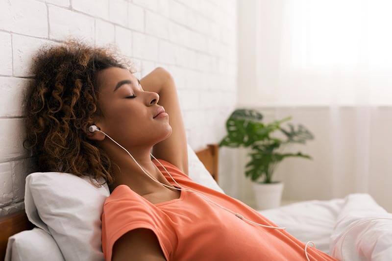 woman relaxing with eyes closed and headphones in