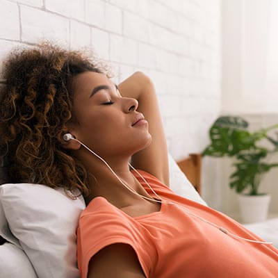 woman relaxing with eyes closed and headphones in